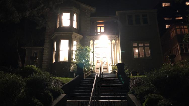 Photo of Inverlochy House which is a Victorian mansion at night, with the steps leading up to the house, the lights are on inside the house.